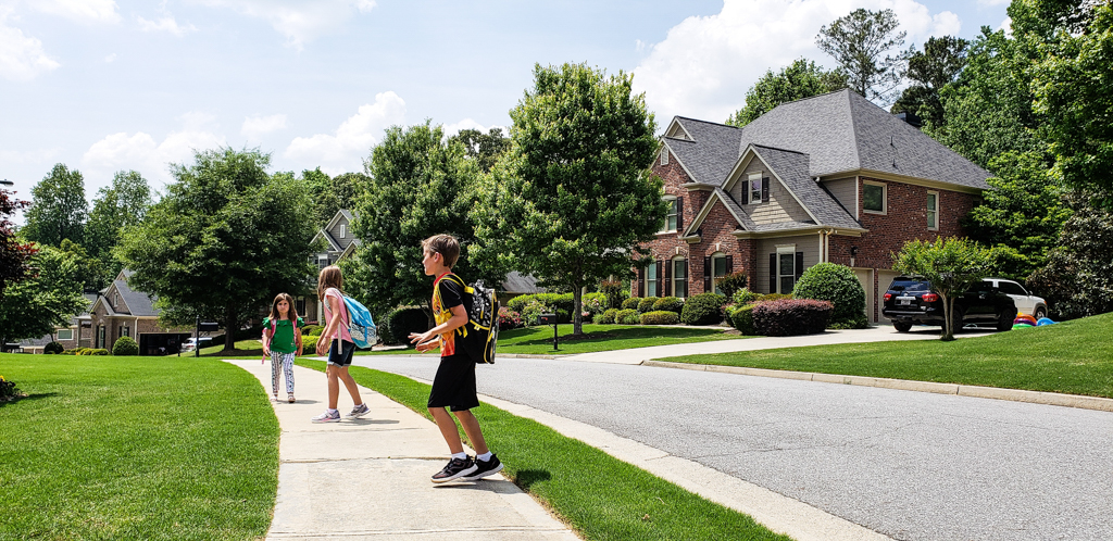 Kids walking in a neighborhood.