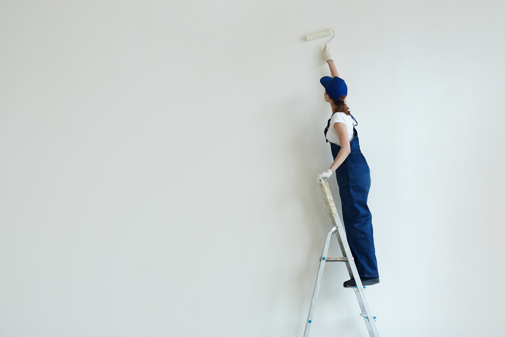 Woman painting a wall with low VOC paints.
